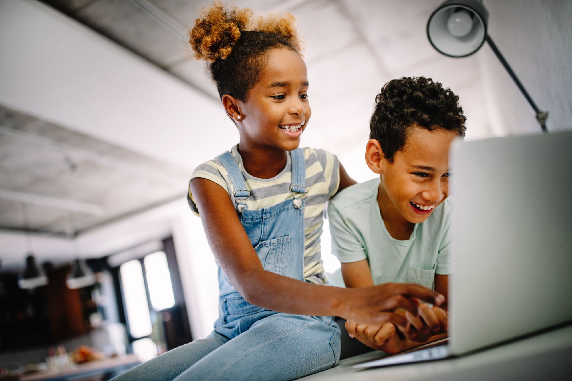 two young african american kids playing on a computer